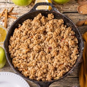 skillet apple crisp recipe with golden brown oatmeal topping over spiced apple slices.