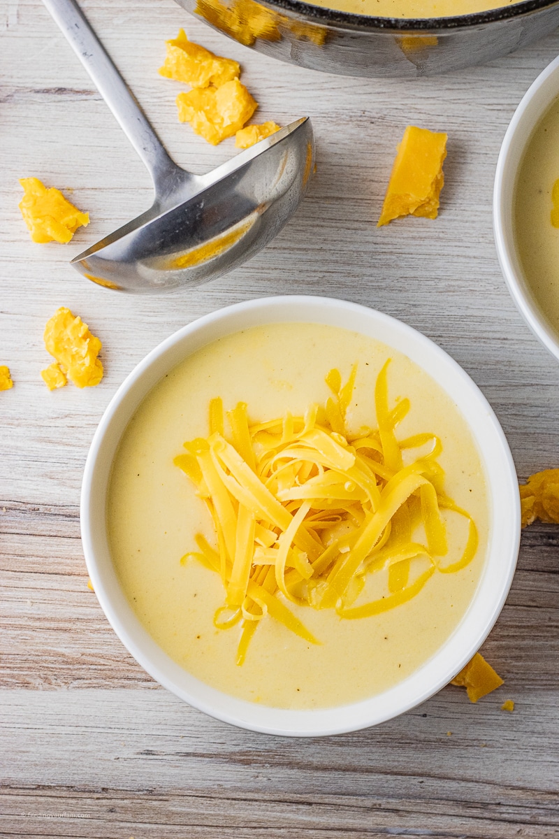 creamy cheesy cauliflower soup topped with grated cheese