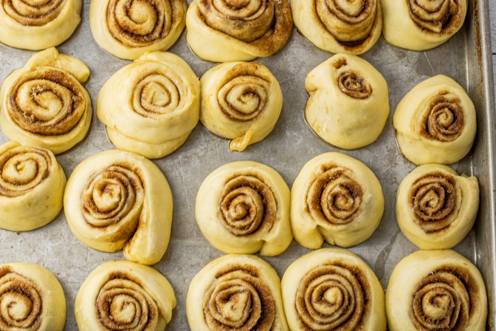 uncooked cinnamon roll dough on a baking sheet