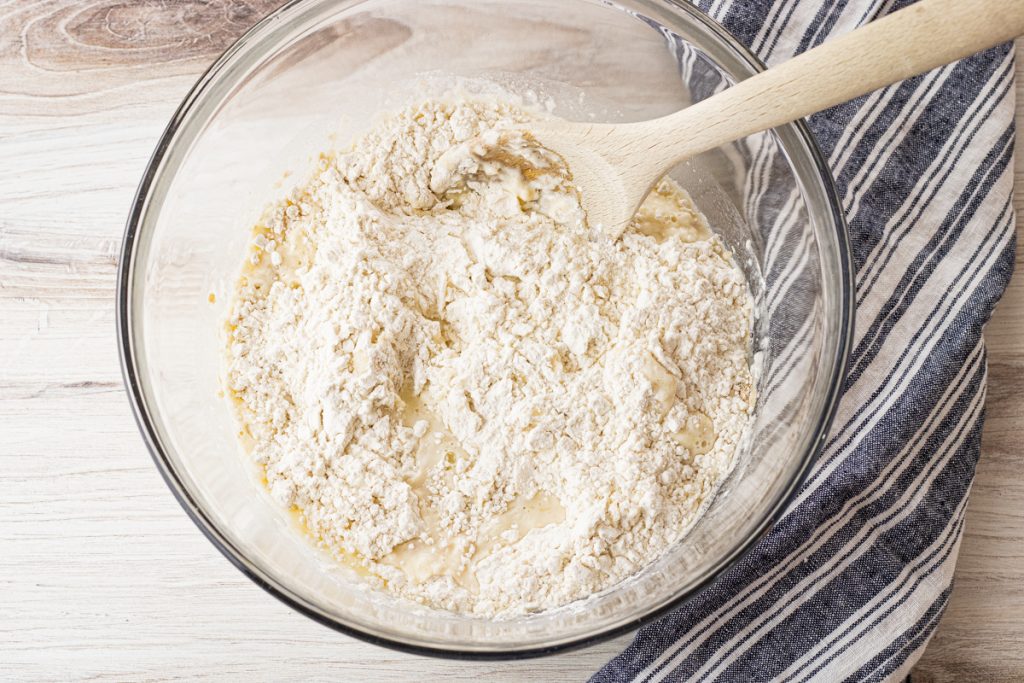 flour in a glass mixing bowl with water and yeast