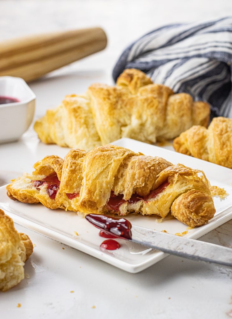 croissant filled with berry jam on a white plate
