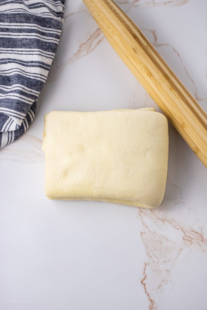 folded dough next to a rolling pin