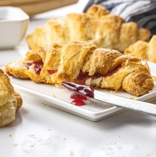 croissant filled with jam on a white plate