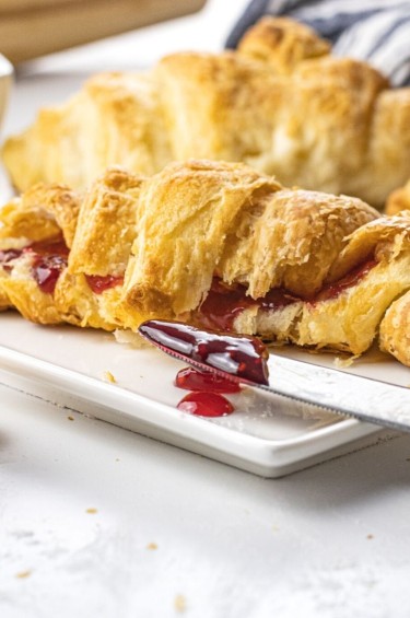croissant filled with jam on a white plate