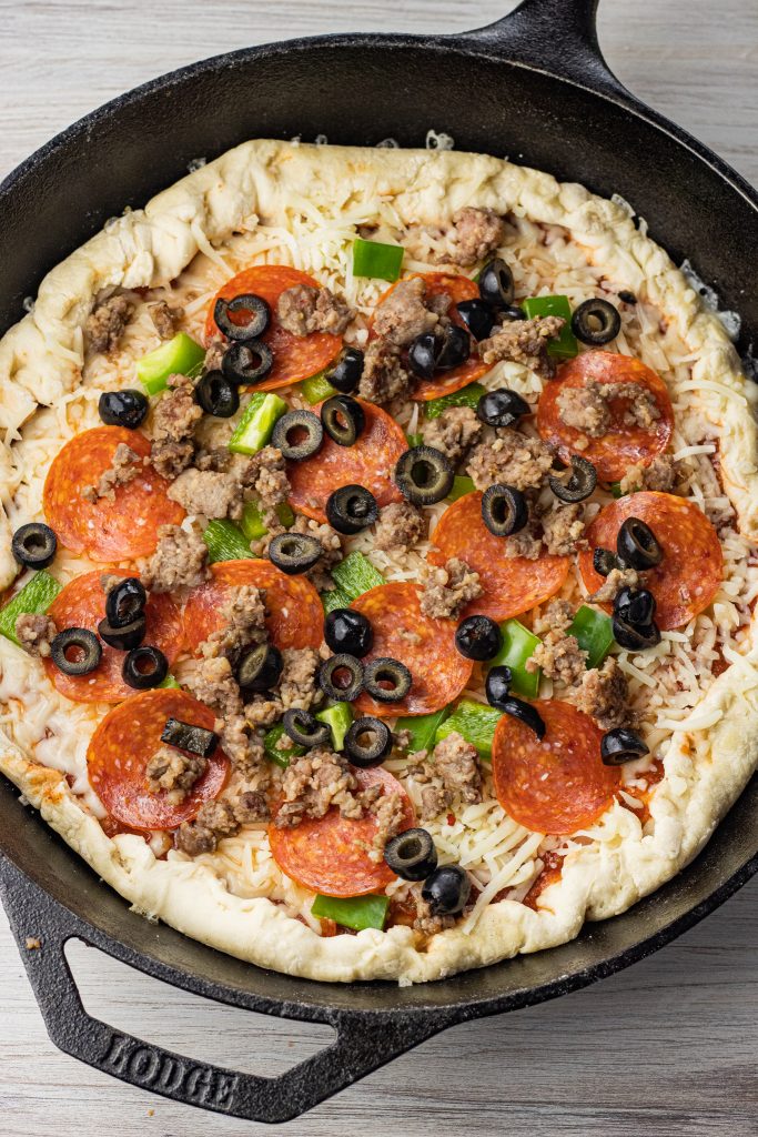 uncooked pizza in a cast iron pan