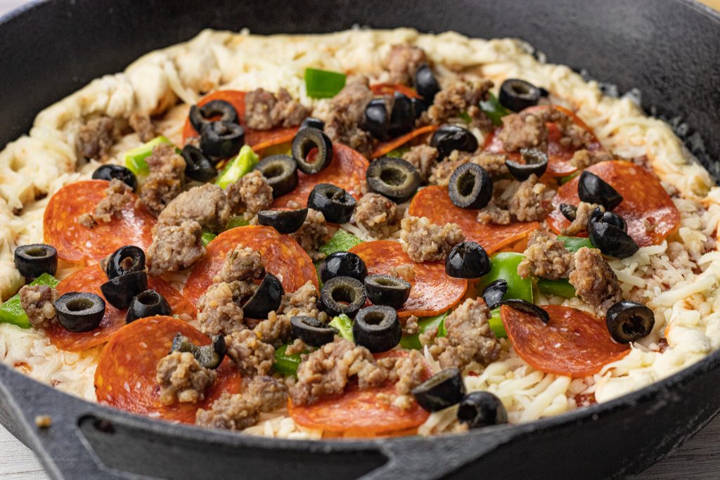 uncooked pizza in a cast iron pan