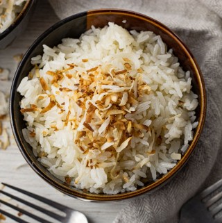 brown bowl filled with rice topped with toasted coconut