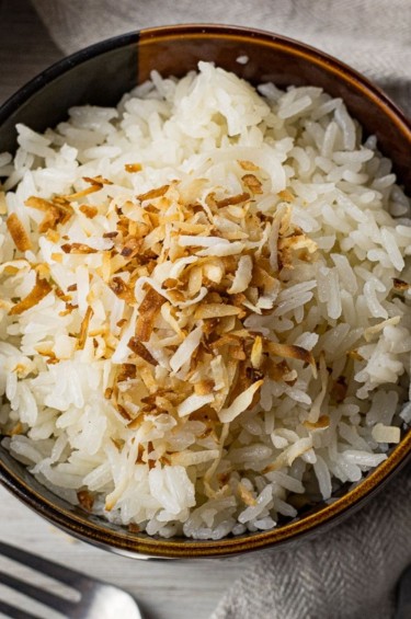 brown bowl filled with rice topped with toasted coconut