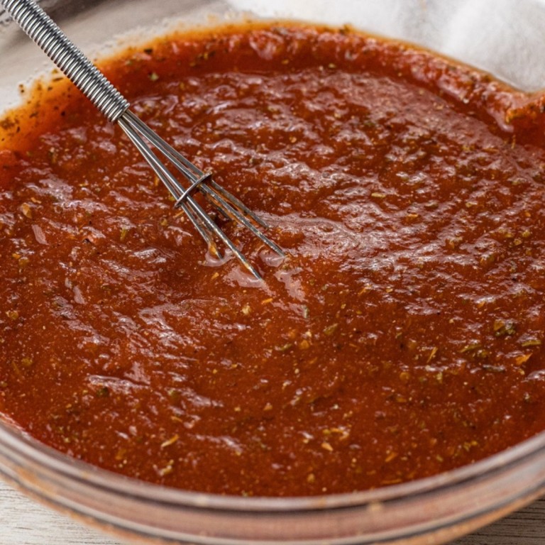 tomato sauce with herbs and spices in a glass bowl