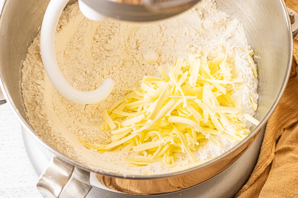 grated butter with flour in a metal mixing bowl