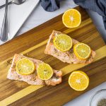 two salmon filets on a wooden cutting board