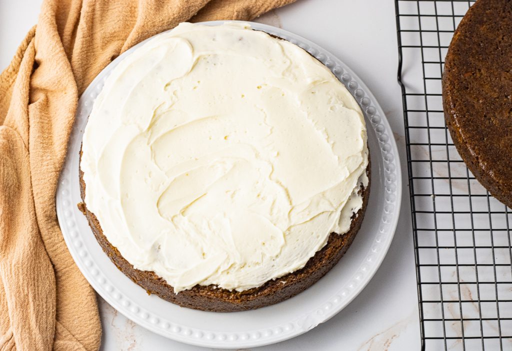 one carrot cake round topped with cream cheese frosting