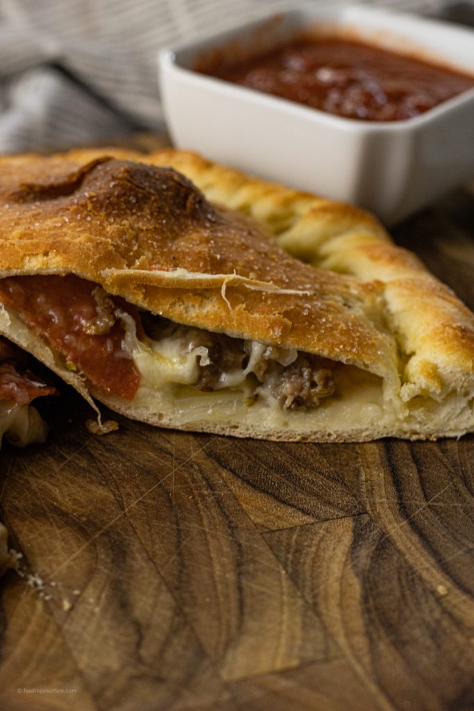 calzone sliced in half with toppings falling out