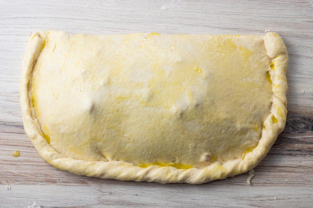 pizza dough filled and folded in half to make a calzone