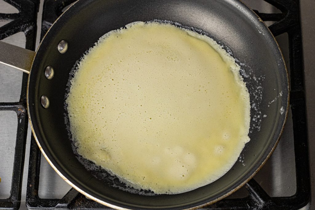 cooking a crepe in a skillet