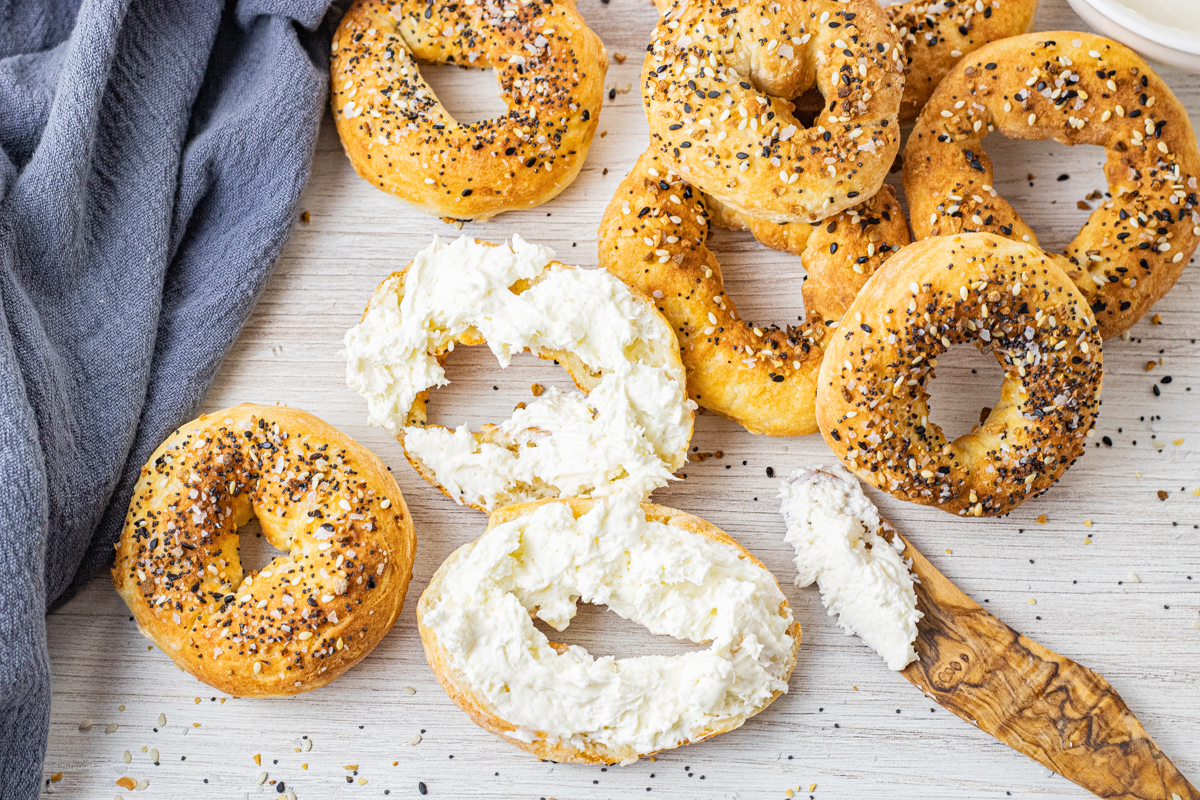 bagels, one sliced and topped with cream cheese