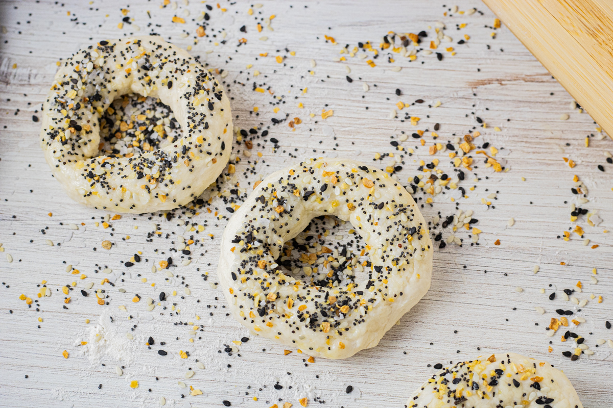 uncooked bagels topped with bagel seasoning