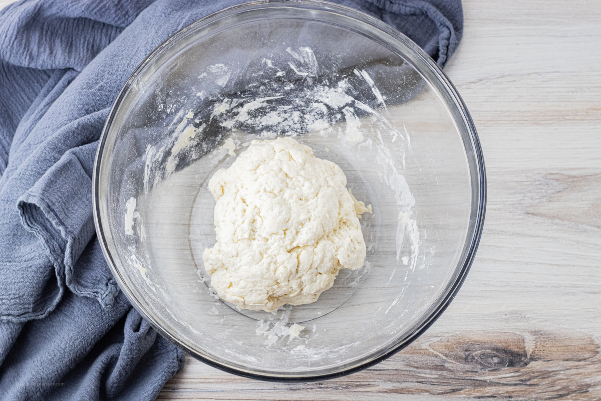 ball of dough in a glass mixing bowl