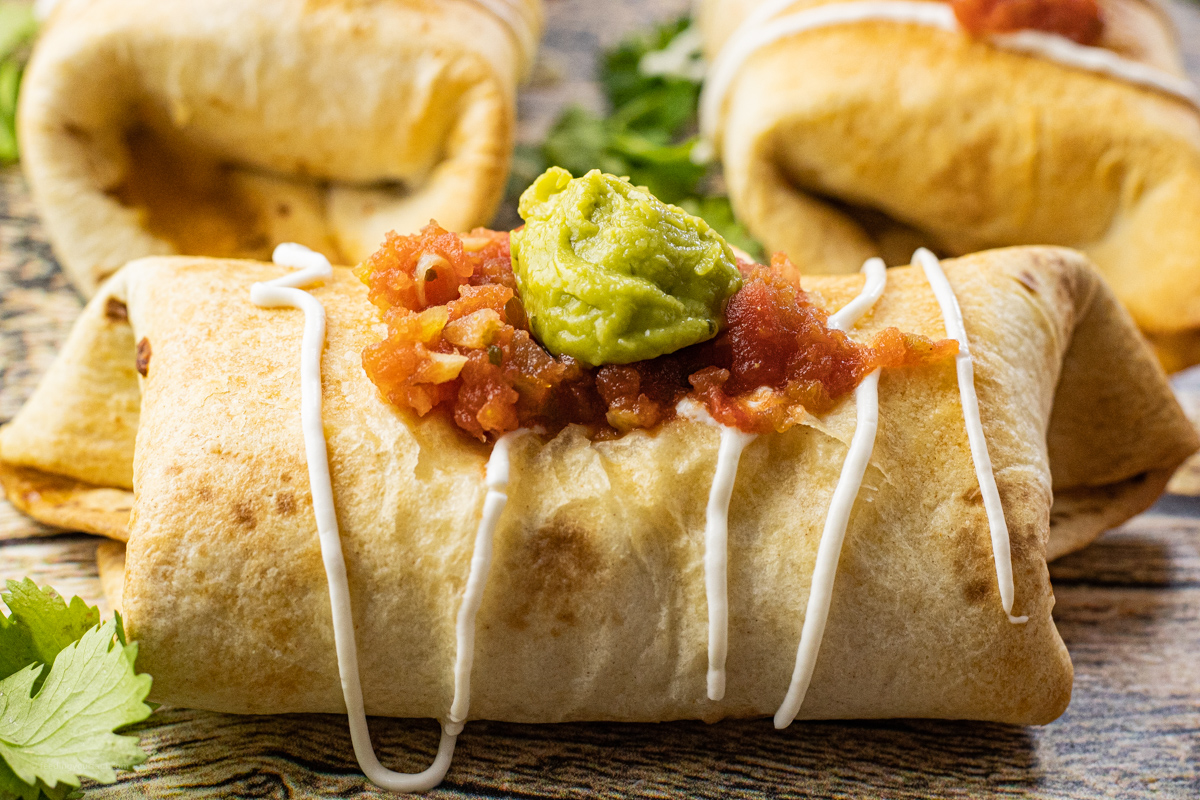 chimichanga topped with salsa and guacamole