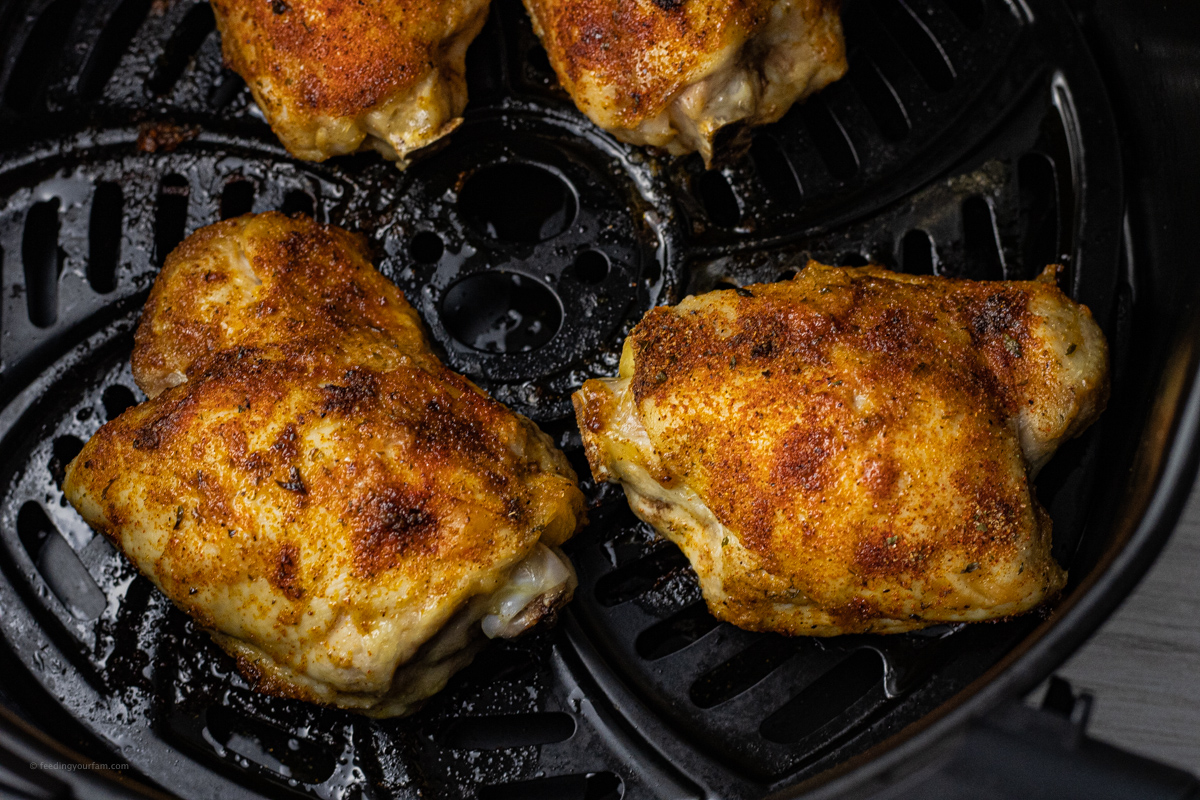 cooked chicken breasts in the basket of an air fryer 