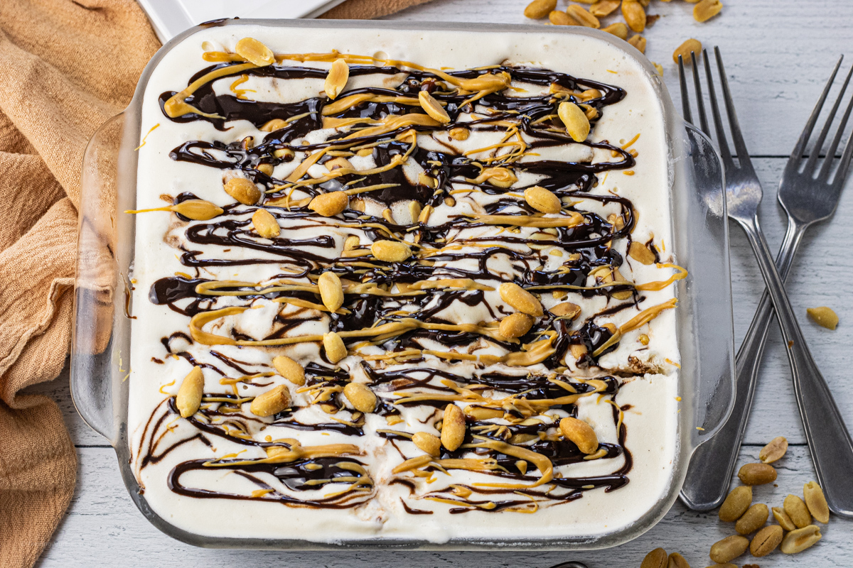 ice cream cake topped with peanuts, hot fudge and peanut butter
