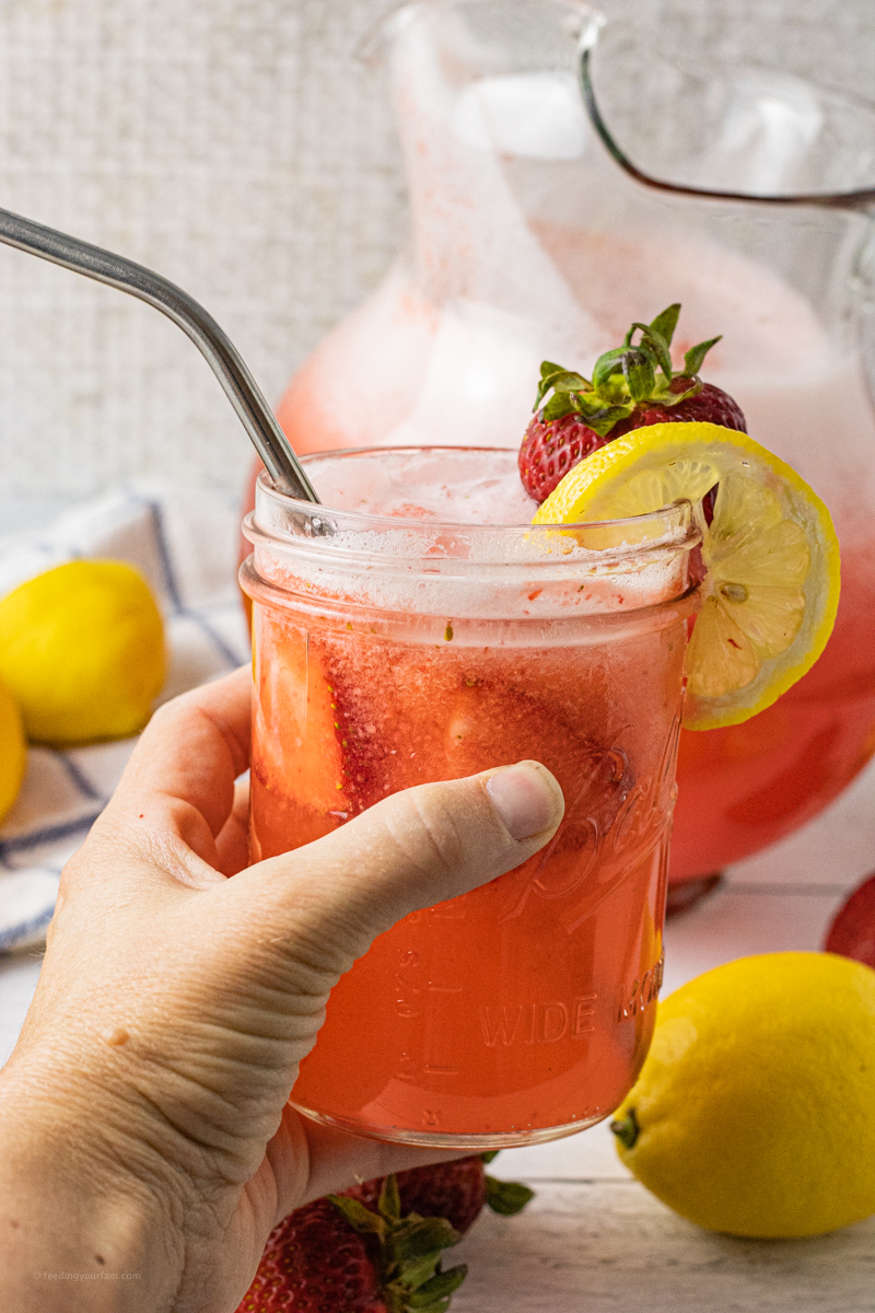 hand holding a jar of strawberry lemonade