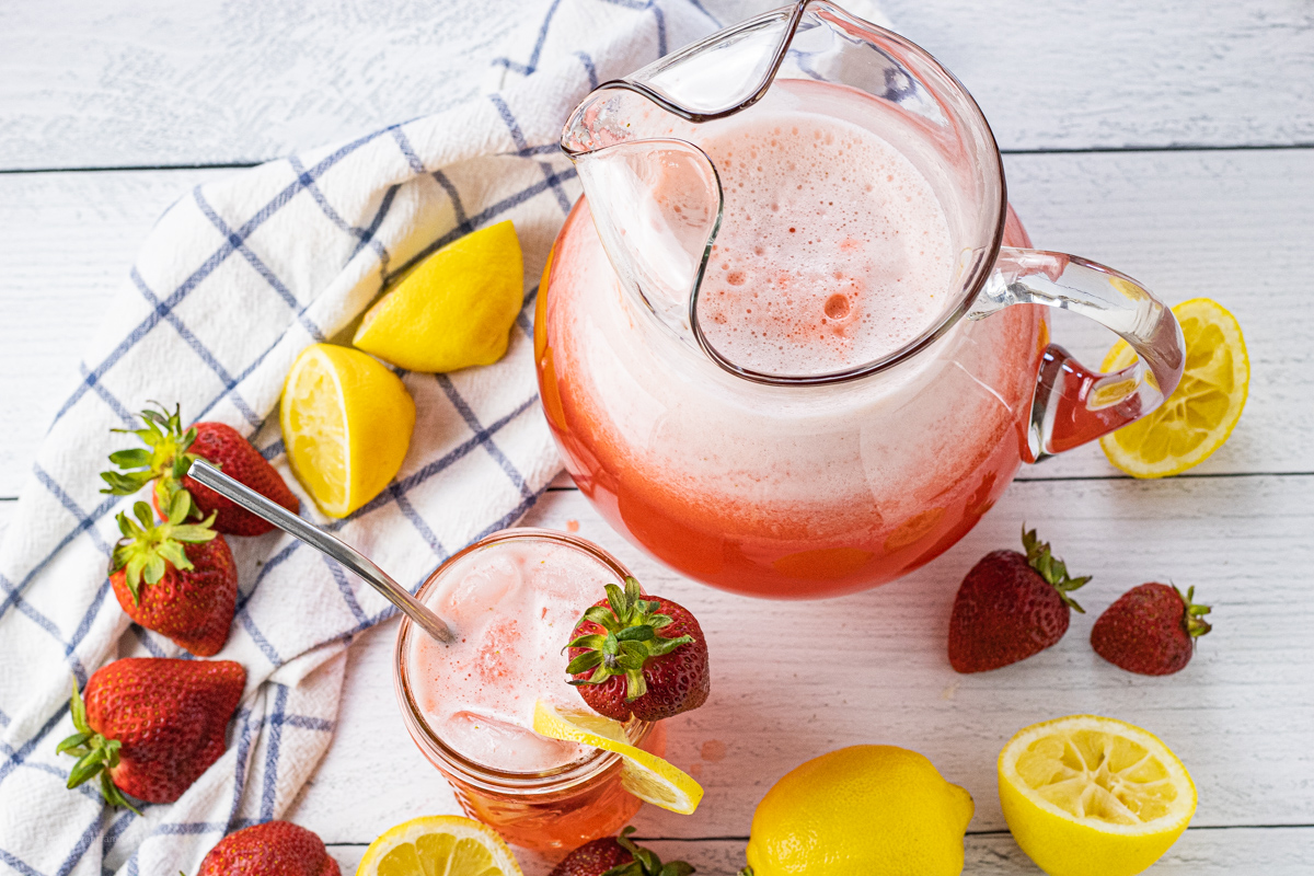 large pitcher or strawberry lemonade with a jar of strawberry lemonade 