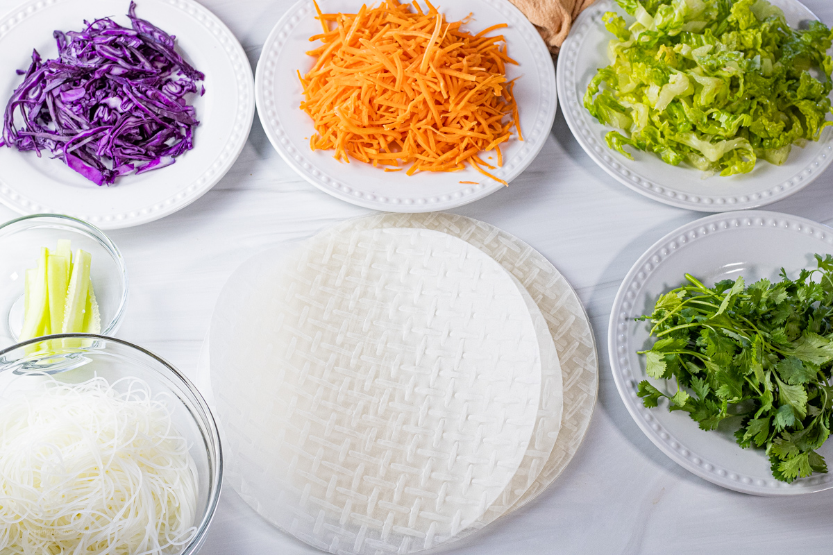 ingredients for spring rolls; rice paper, cucumber, red cabbage, carrots, cilantro