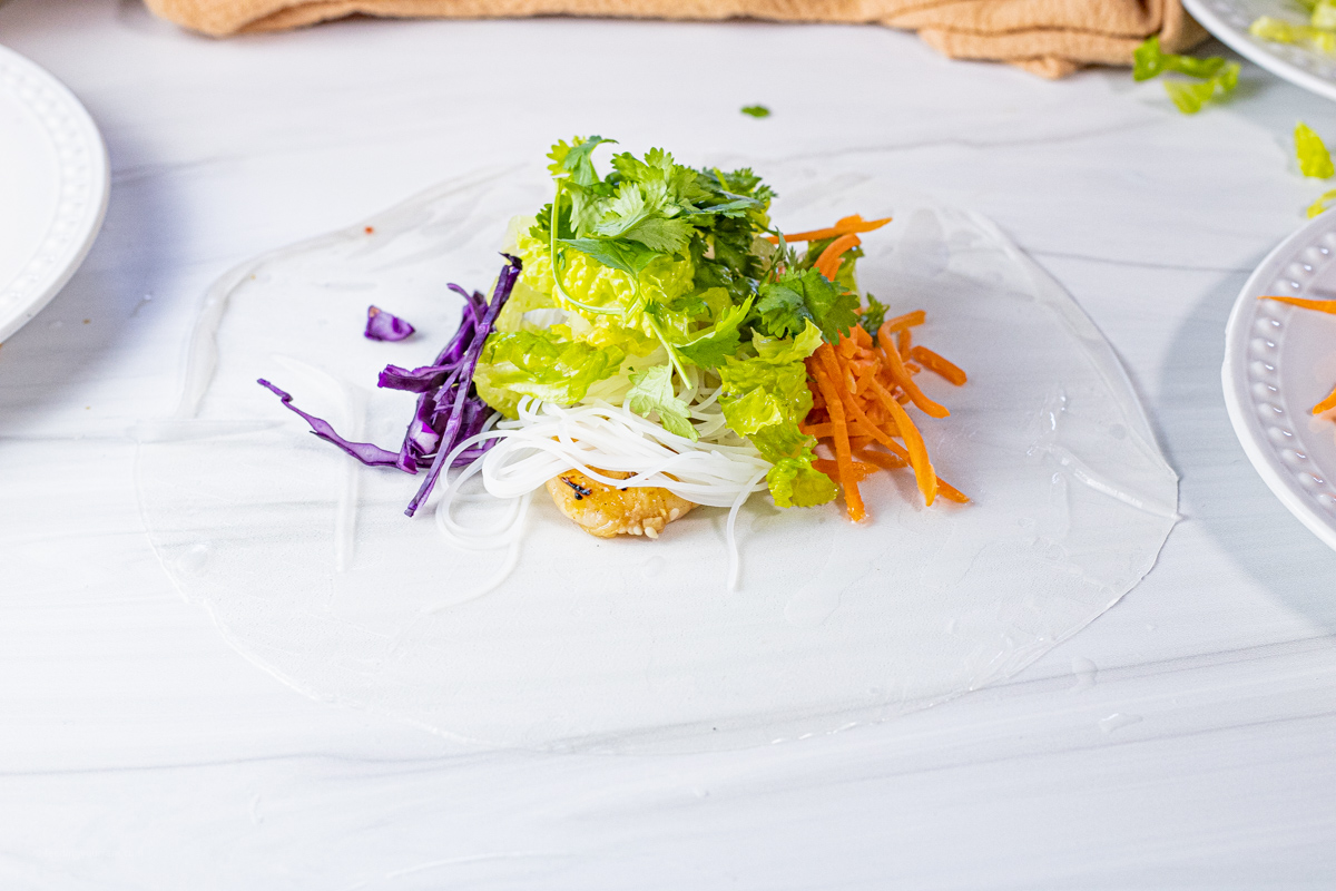 rice paper with shrimp, noodles, carrots, lettuce and cabbage in the center