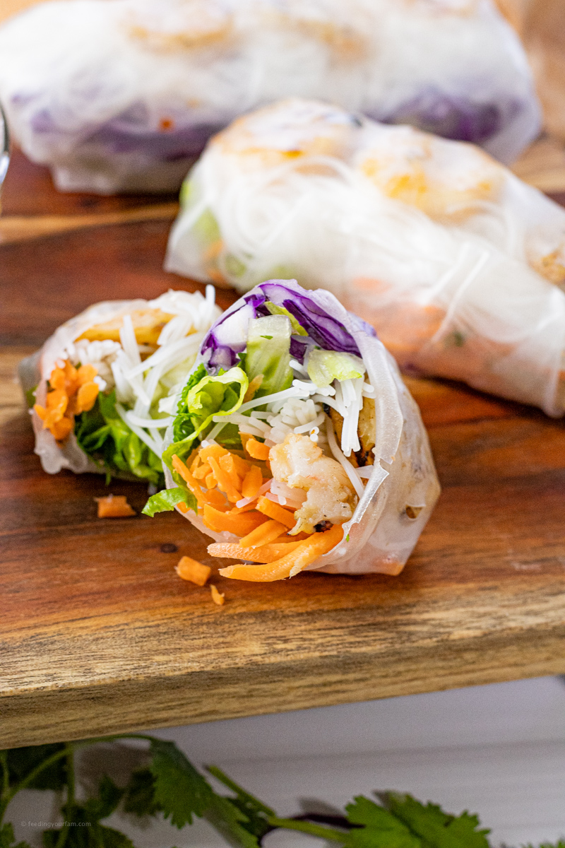 spring rolls with carrots, red cabbage, lettuce, rice noodles and shrimp. Sliced in half to show inside. 
