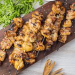 grilled chicken skewers on a wooden cutting board
