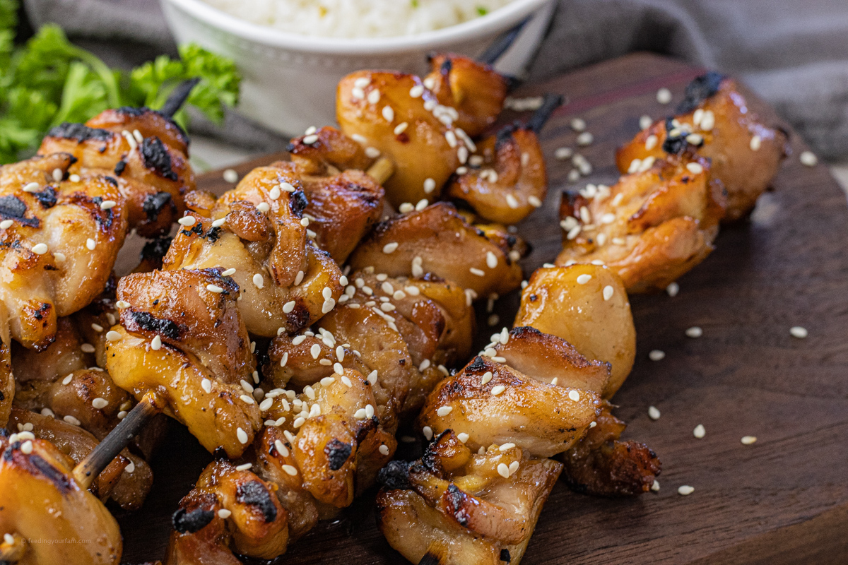 grilled chicken on wooden skewers topped with sesame seeds 