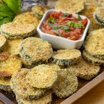 oven baked zucchini rounds on a wooden platter
