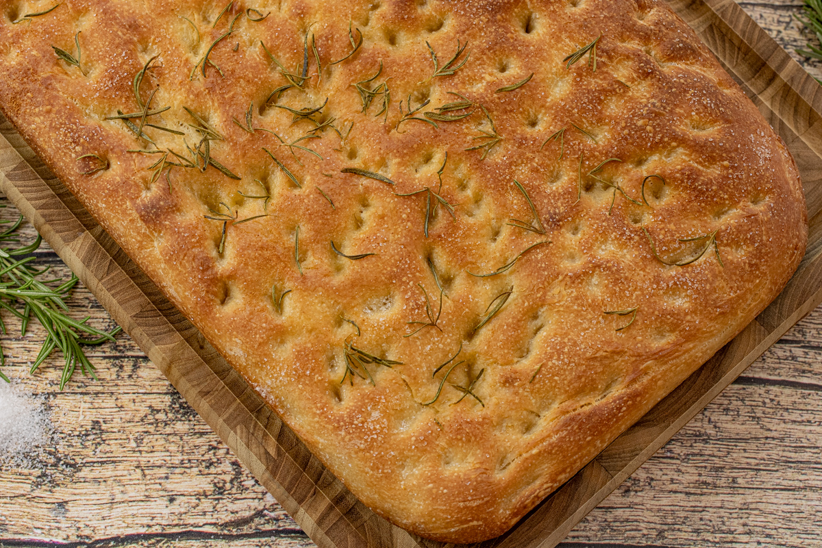 cooked focaccia on a wooden cutting board