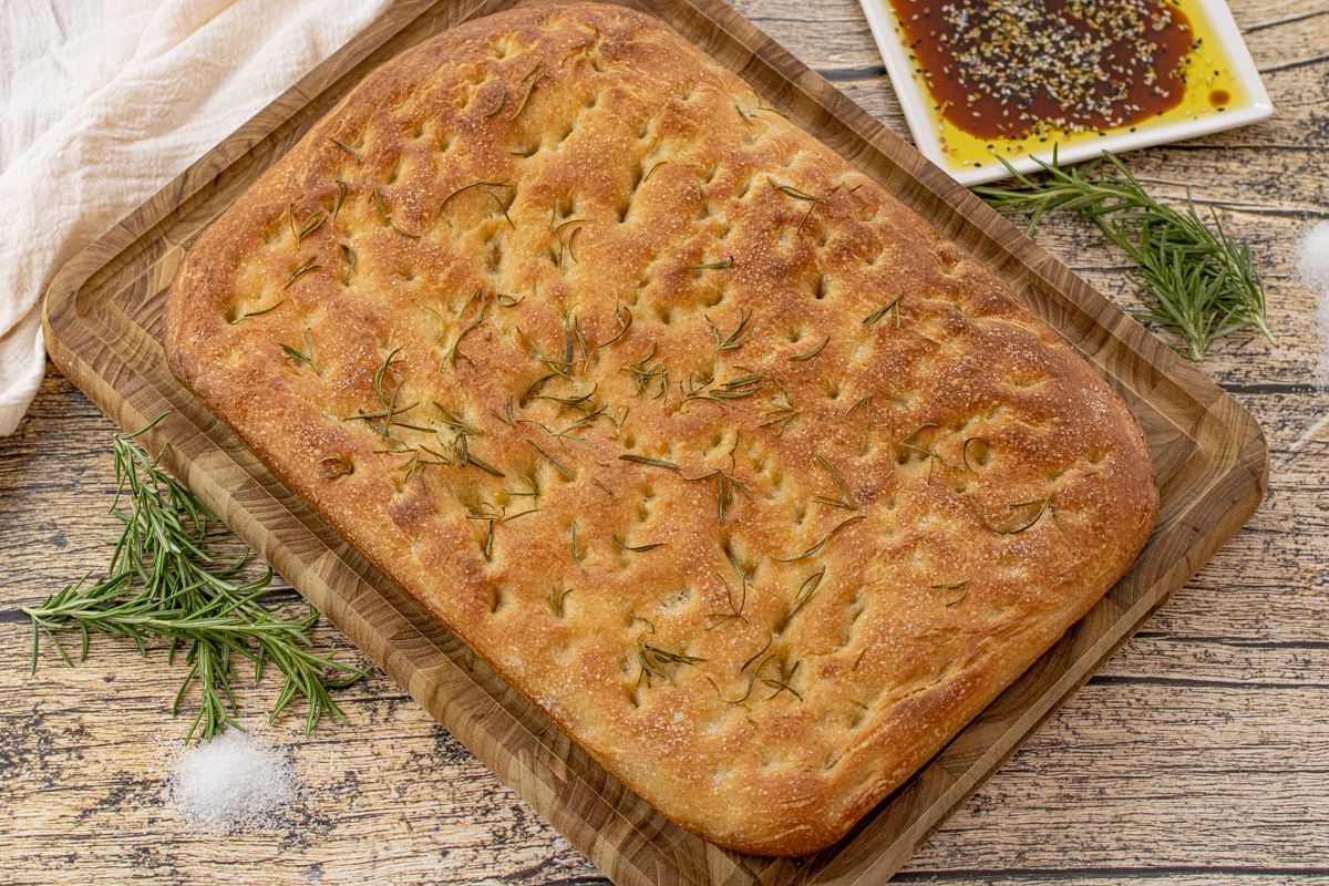 square slab of focaccia bread topped with rosemary