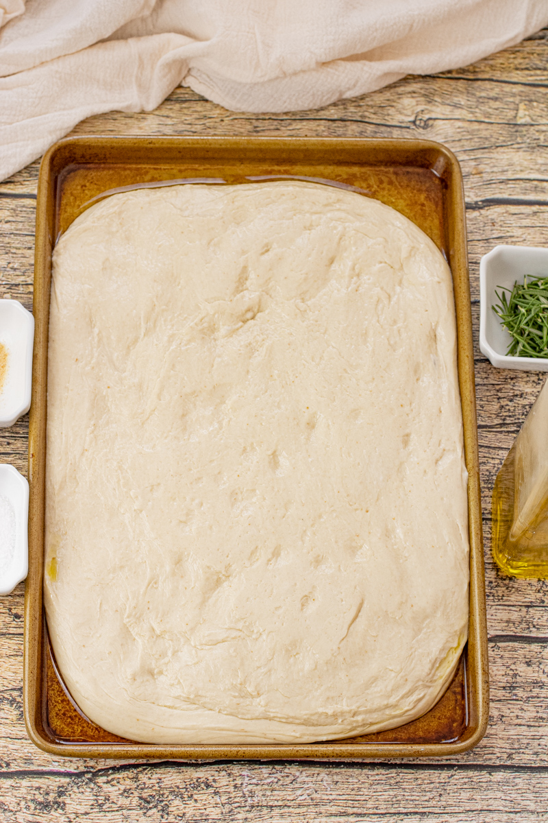 focaccia dough uncooked on a baking sheet