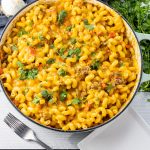 big pan of twisty noodles with ground beef, cheese and cilantro