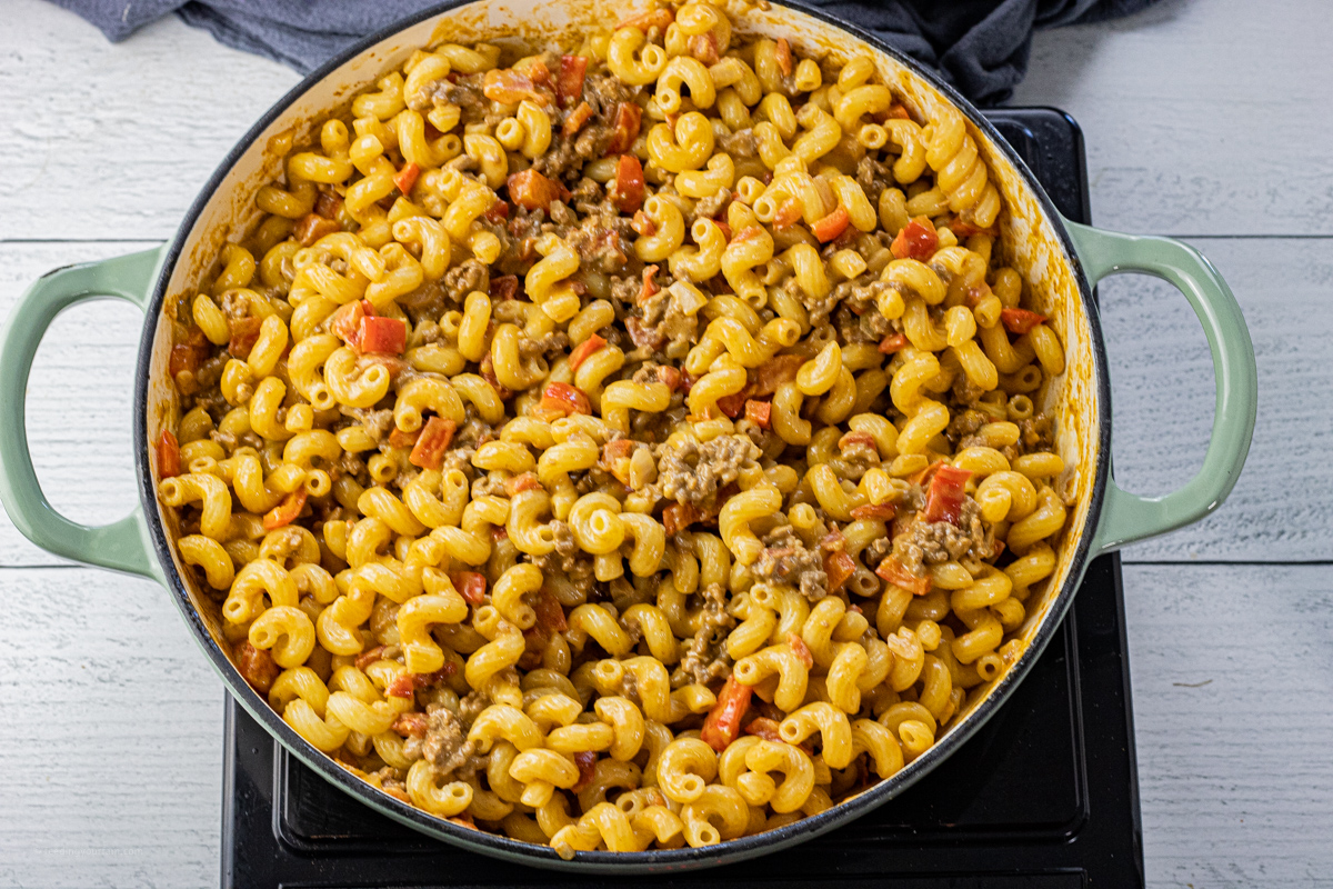 twisty pasta in a large cast iron skillet with cheese and ground beef