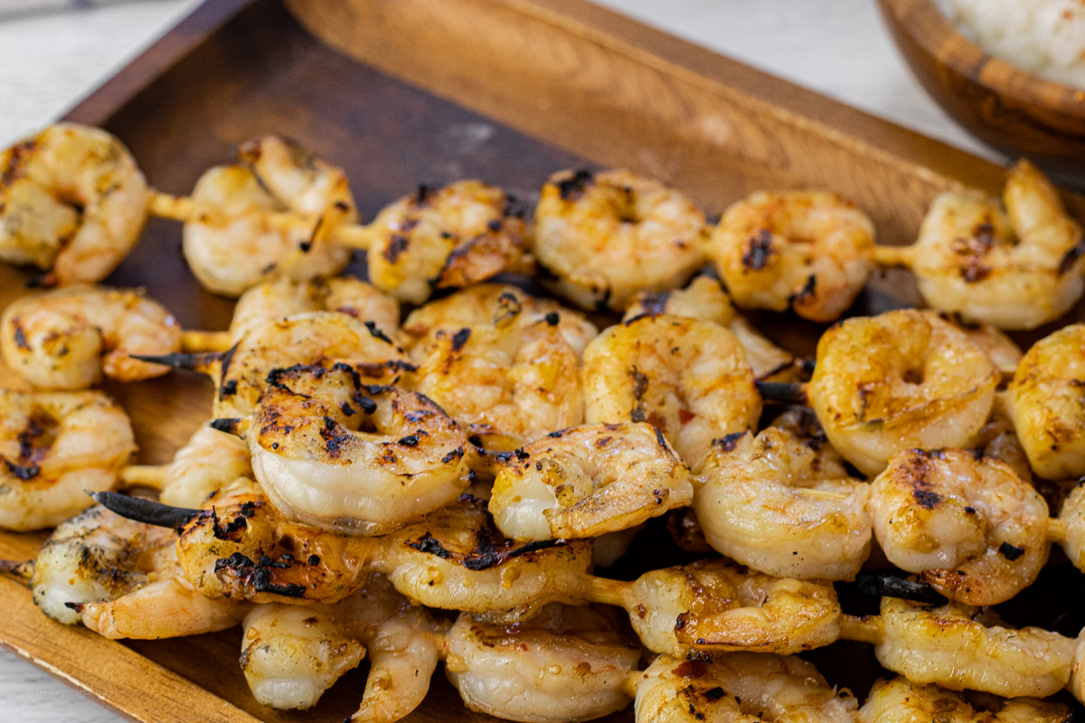 grilled shrimp on skewers on a wooden platter