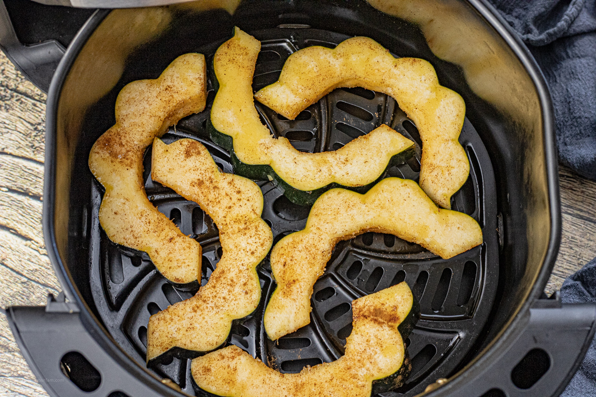 acorn squash slices in the basket of an air fryer