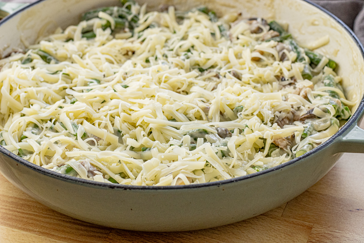 green bean casserole topped with shredded swiss cheese uncooked