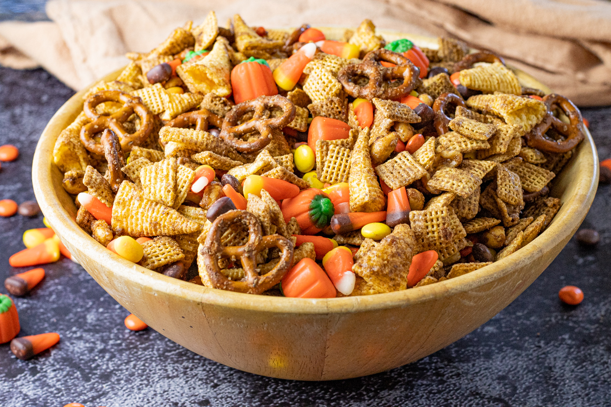 Chex mix with candy corn, pretzels, candy pumpkins and Reeses candies