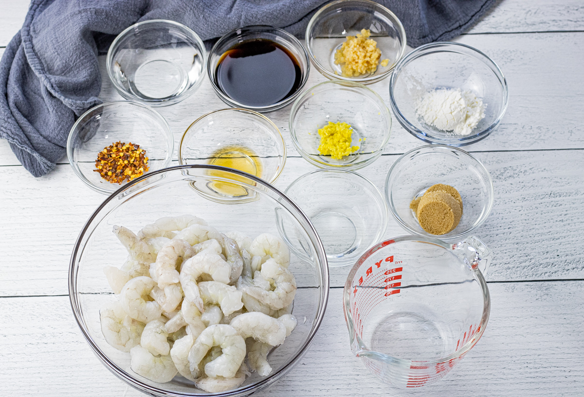 glass bowls of ingredients, soy sauce, garlic, ginger, red pepper flakes, shrimp, brown sugar