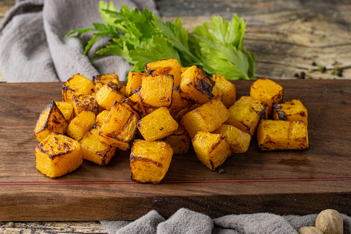 cubes of squash on a wooden cutting board