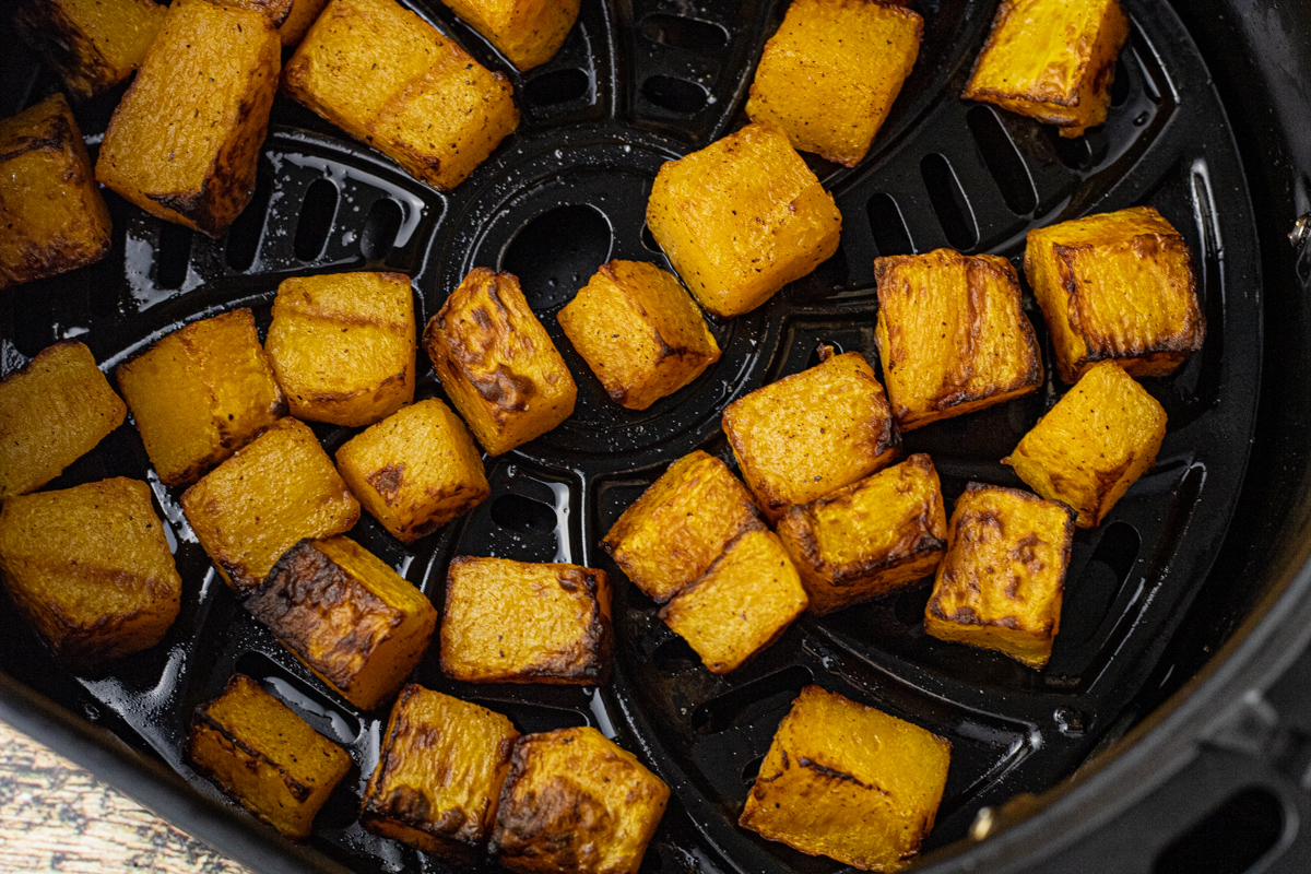 small pieces of squash cooked in an air fryer basket