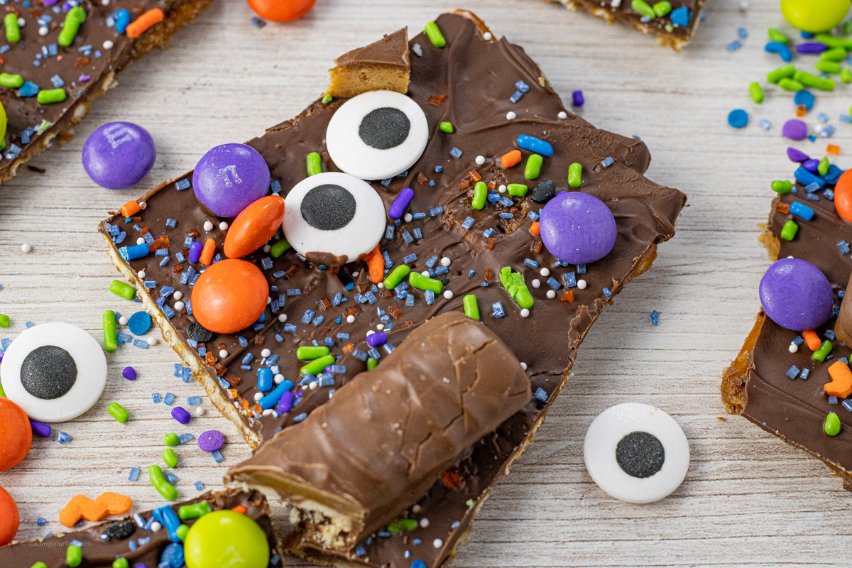 pieces of pretzels covered with toffee, chocolate, sprinkles, eye candy and halloween candy