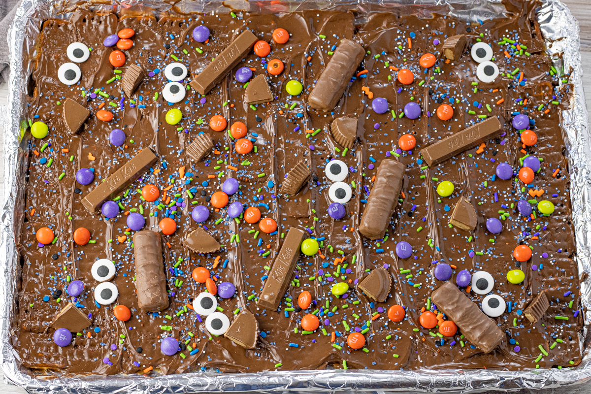 pretzels covered with toffee, melted chocolate, sprinkle, eye candies and halloween candies