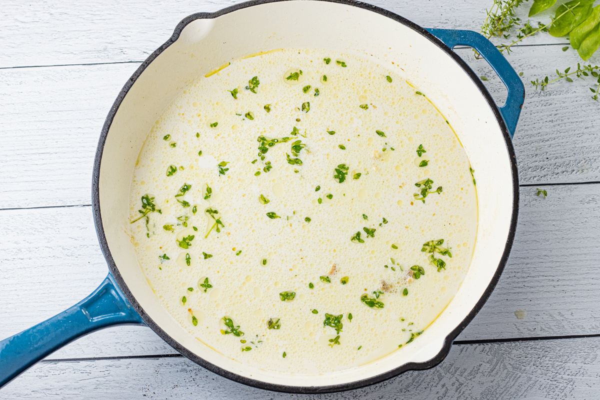 cream with thyme in a cast iron enameled skillet