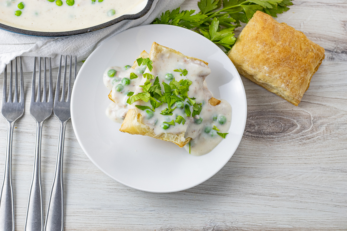 pieces of puff pastry topped with a white tuna gravy with peas