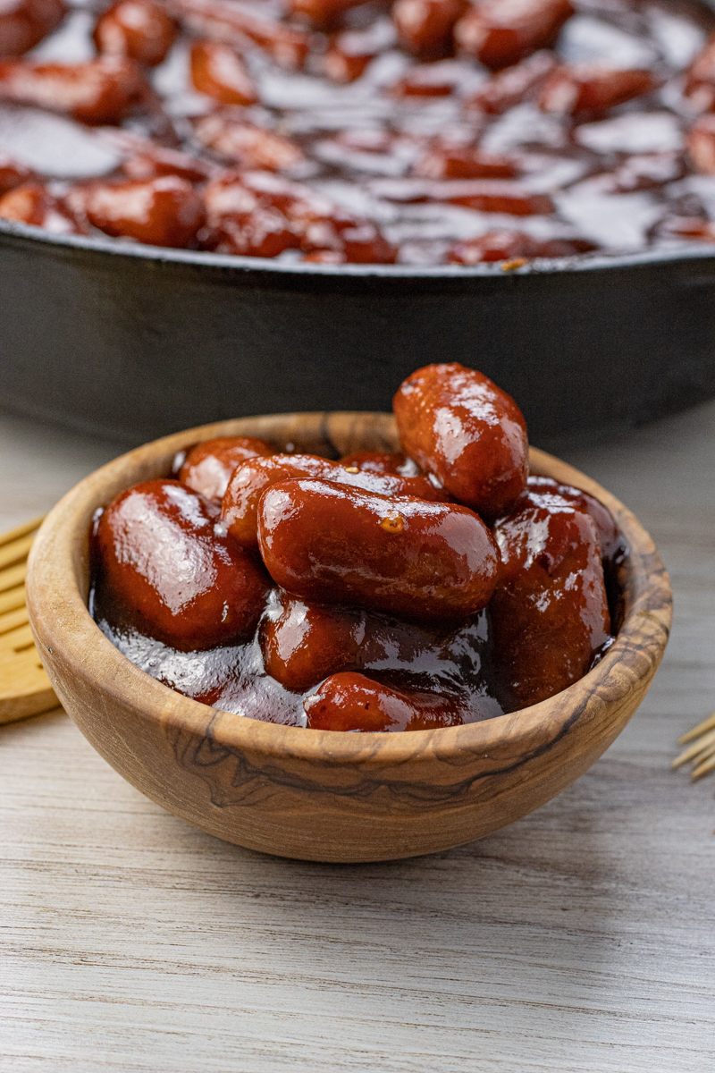 small wooden bowl filled with mini sausages in bbq sauce